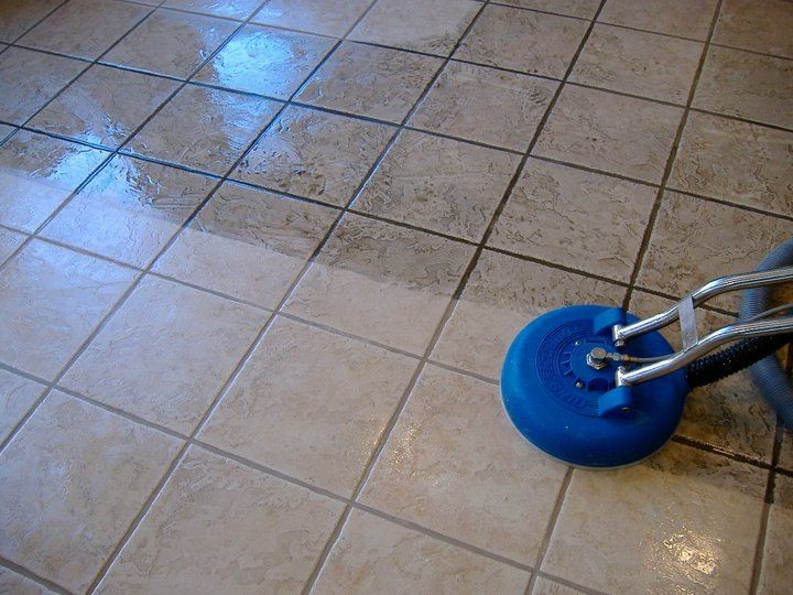 Floor cleaning machine polishing tile floor, showing a distinct difference between cleaned and uncleaned sections.